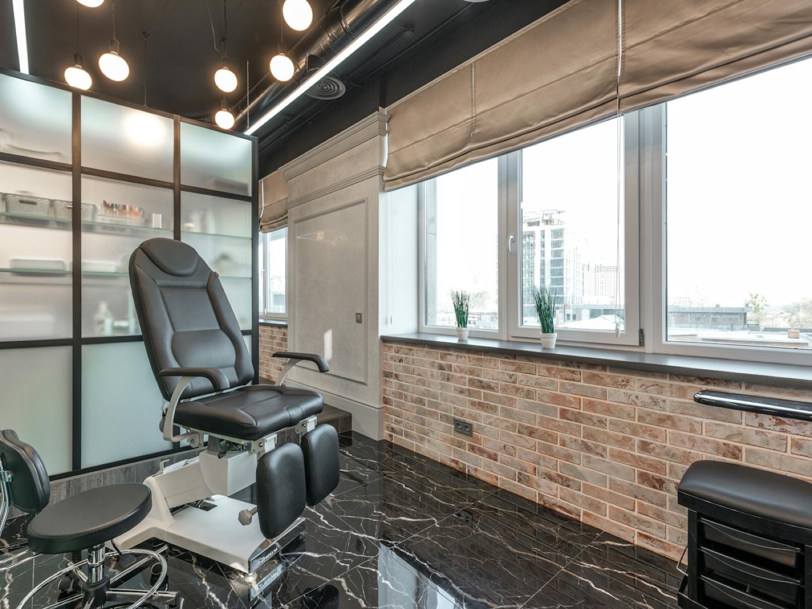 Bright salon treatment room with a reclining chair beside large windows